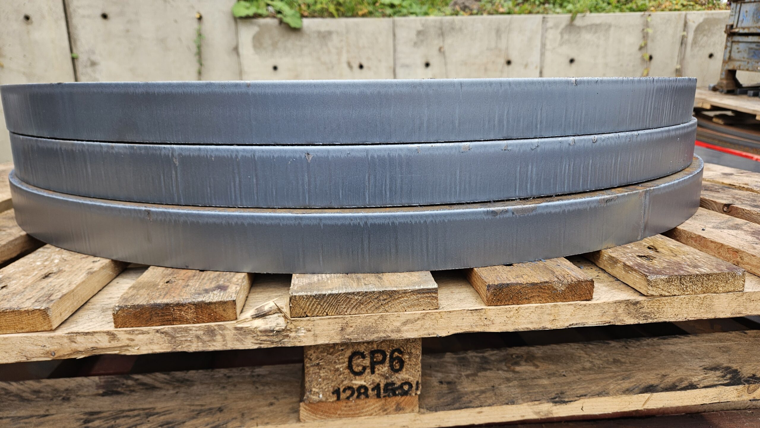 Smooth side of steel circles that were plasma cut.