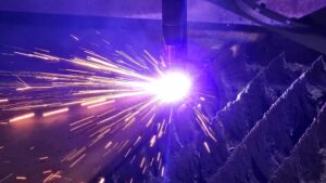 Close up of plasma cutting machine cutting a sheet of steel.