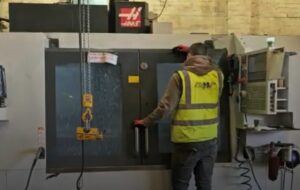 Someone using a CNC milling machine.